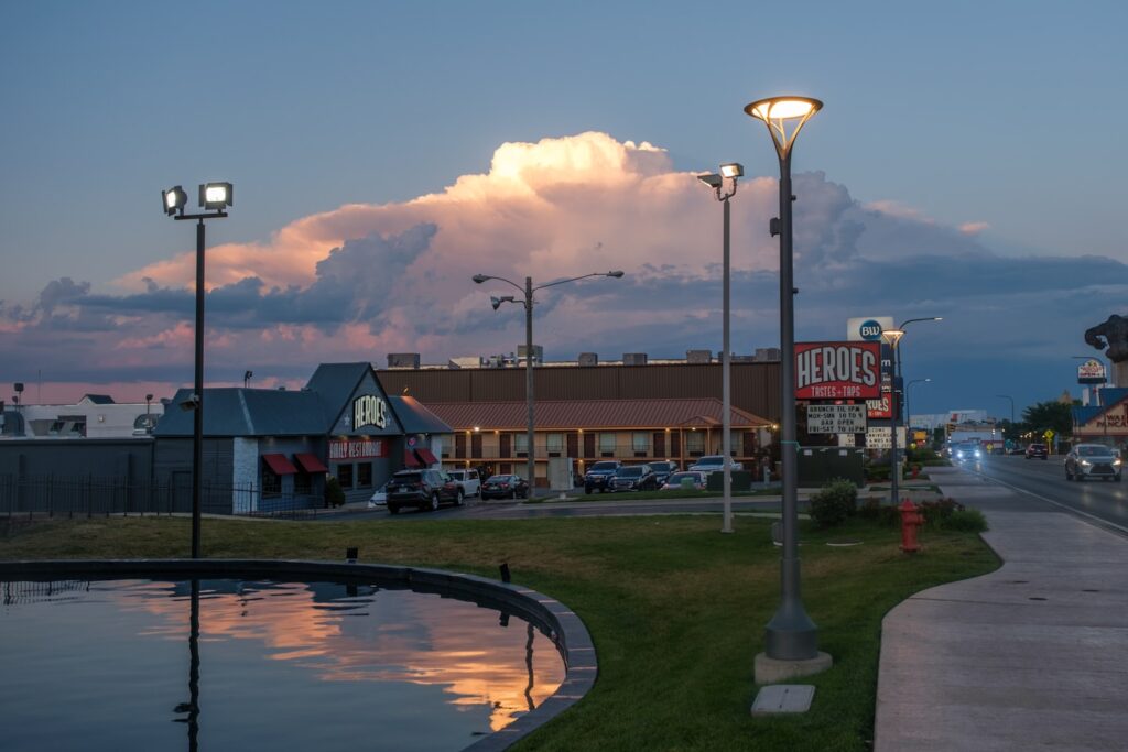 Buildings and streetlights at dusk with large cloud formation.