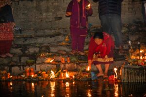Devotees lighting oil lamps on the riverbank during evening ritual at Pashupatinath Temple, Kathmandu