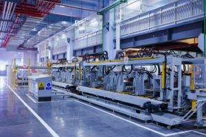 A view of the refrigerator manufacturing plant's fully automated side panel forming line.Translation: "Warning:Danger Prohibit reach into;elecric shock;must connect an earth terminal to the ground"